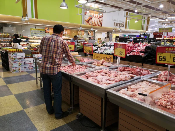 CHIANG RAI, TAILANDIA - 23 DE SEPTIEMBRE: Hombre asiático no identificado eligiendo carne en el supermercado el 23 de septiembre de 2019 en Chiang Rai, Tailandia . — Foto de Stock