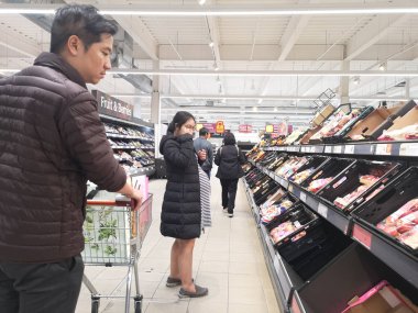 Londra, Uk - 7 Ekim: Kimliği belirsiz Asyalı müşteri 7 Ekim 2019 'da Londra, Uk' ta süpermarkette yiyecek arıyor..