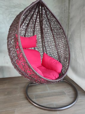 Sallanan salıncak ve odanın köşesinde kırmızı yumuşak yastık