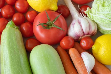 Açık bir yüzeyde taze olgun sebzelerin yakın çekimi. Sağlıklı beslenme, vejetaryenlik kavramı. Yatay yönelim, seçici odaklanma. Yukarıdan görüntüle.