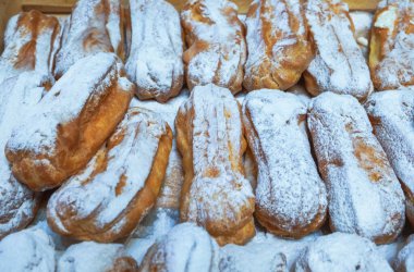Kremalı hamur hamurundan üzerine pudra şekeri serpiştirilmiş ekler yakın plan.