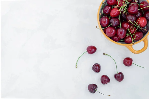 Vy ovanifrån på skålen med färska mogna röda körsbär på en ljus bakgrund — Stockfoto