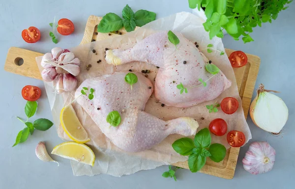 Baharatlı tavuk butları ve ahşap kesim tahtasında pişirmek için mutfak otları. Yatay yönelim, seçici odaklanma, üst görünüm. Sağlıklı yemek..