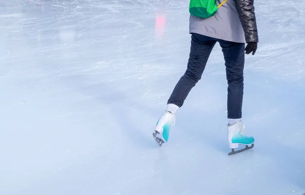A young girl skating in winter clothes for outdoor activities at the rink in winter. — Stock Photo, Image