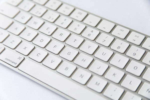 aluminum computer keyboard with white keys on a white background