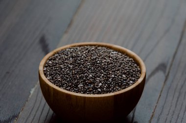 Sağlıklı Chia tohumları yakın plandaki tahta kasede.