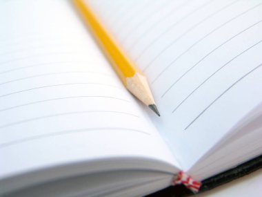 yellow pencil inside of empty textbook 