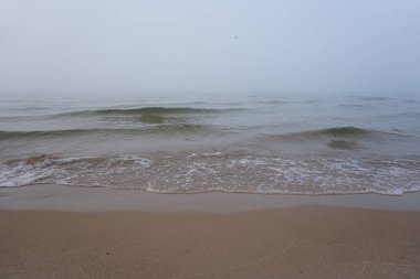 Deniz, plaj ve arka planda sis