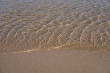 Su üzerinde dalgaların kum yüzeyi