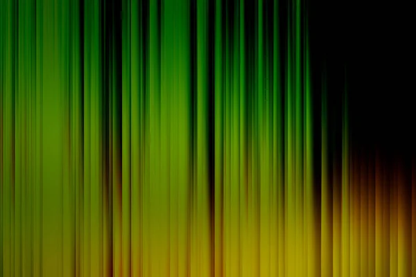 Blurred lines of green, yellow and orange over black blend to create abstract background