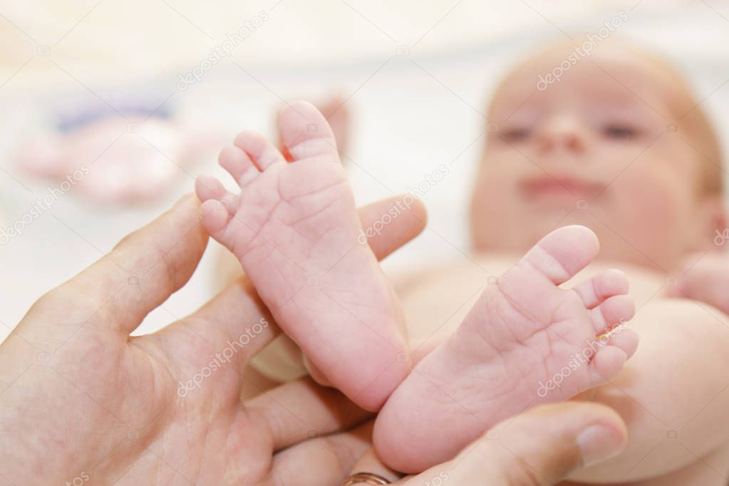 Father holds newborn babys feets. Tiny legs in mans hand