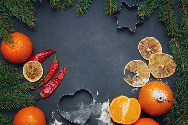 Spices flour orange food pine tree branchon a black board winter christmas background