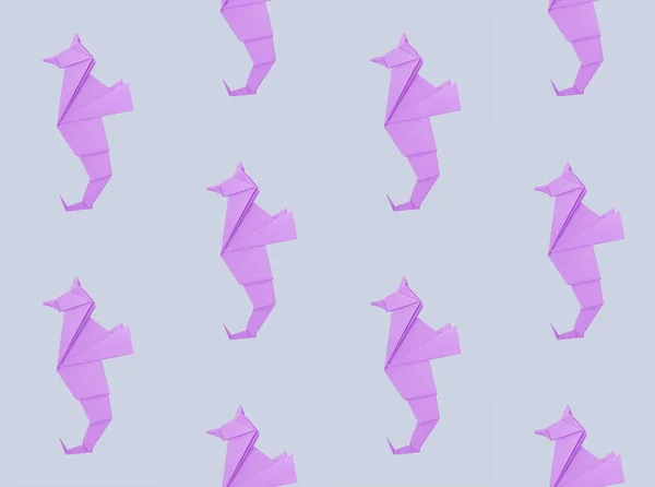 Abstrakt origami sjöhäst isolerad på en grå bakgrund mönster Stockbild