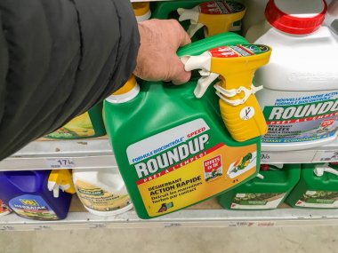 Paris, France - January 25, 2019: Customer buying roundup in a french Hypermarket. Roundup is a brand-name of an herbicide containing glyphosate, made by Monsanto Company.