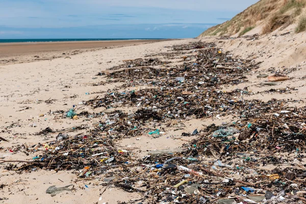 Residuos de plástico lavados en una playa . —  Fotos de Stock