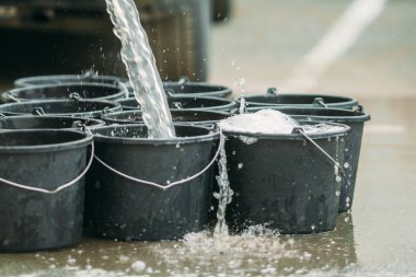 su sokakta siyah plastik kovaiçine dökülür