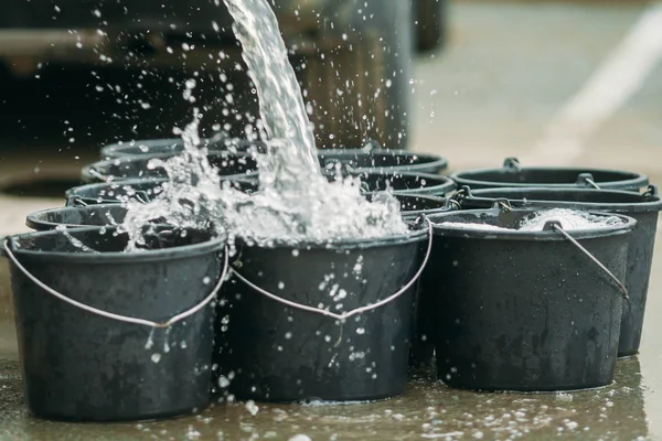 su sokakta siyah plastik kovaiçine dökülür