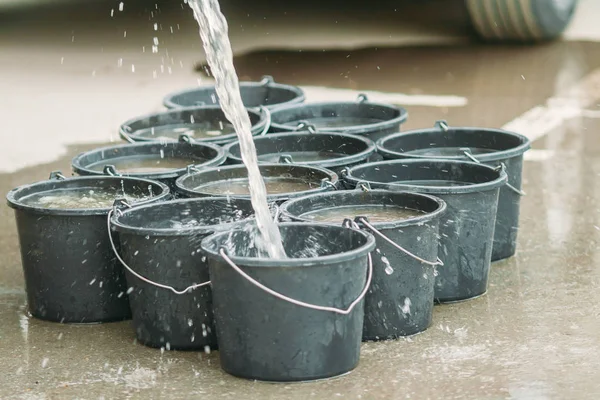 su sokakta siyah plastik kovaiçine dökülür