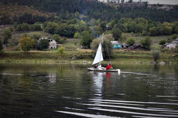 bir tekne nehirde yüzen gezginler