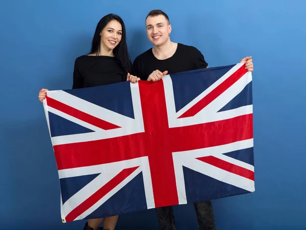 Young man and woman with the flag of Great  Britain on a blue background.  Students are English.