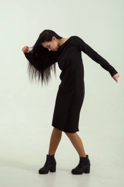 Siyah elbiseli bir esmer moda kadın.