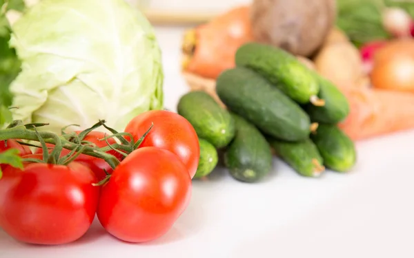 Fresh seasonal vegetables for salad or other vegetable dishes. Cabbage, tomato, cucumber, onions - healthy food.