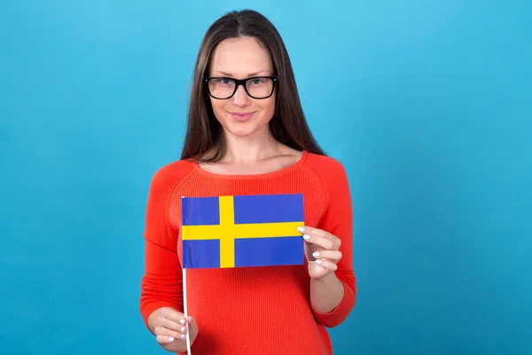 Hermosa Mujer Morena Gafas Sostiene Bandera Suecia Sobre Fondo Azul — Foto de Stock