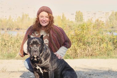 Yetişkin kadın Parkı'nda büyük köpeğiyle oynuyor. Sonbahar. Yaşam tarzı ve dostluk kavramları.   