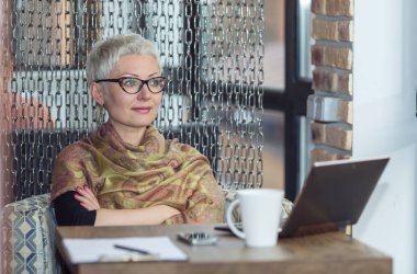 Bir dizüstü bilgisayarda kapalı çalışan iş kadın.