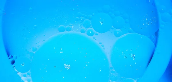 Lingkaran Minyak Pada Latar Belakang Air Biru Latar Belakang Abstrak — Stok Foto