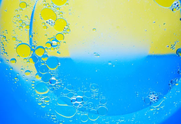 Lingkaran Minyak Pada Latar Belakang Air Biru Dan Kuning Latar — Stok Foto