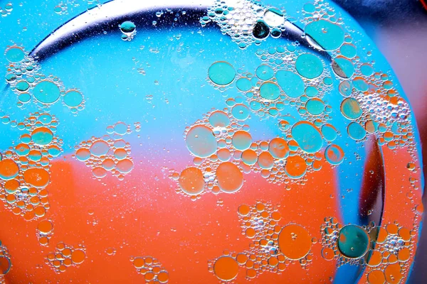 Circles of oil on water blue orange background. Abstract background for text.