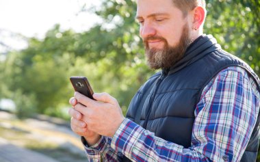 Bir akıllı telefon ile bir sakallı iletiyi okur.