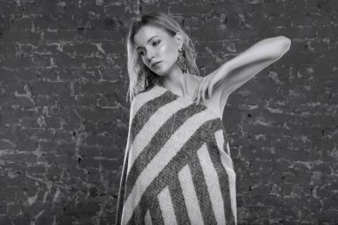 Güzel seksi kadın sarışın bir battaniyeye giyinmiş. Model moda. Siyah beyaz fotoğraf.