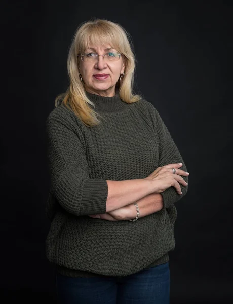 Senior woman. Portrait of a mature woman 60 years old on a dark background.