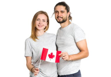 Happy couple of young people with the flag of Canada on a light background. Male and female Canadians, patriots. clipart
