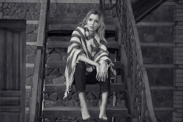 黑色白色的照片 一个年轻女孩的肖像坐在楼梯上在家里 — 图库照片