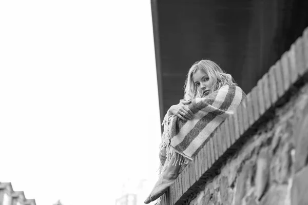 黑白照片 画像的一个年轻的悲伤的女人坐在房子附近的石栅栏上 — 图库照片