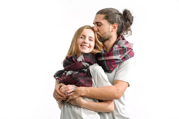 Kiss. Young couple in love in shirts and scarves standing on a light background. Man and woman.