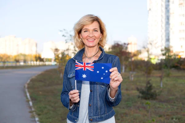 熟女は市と青い空を背景にオーストラリアの旗 — ストック写真