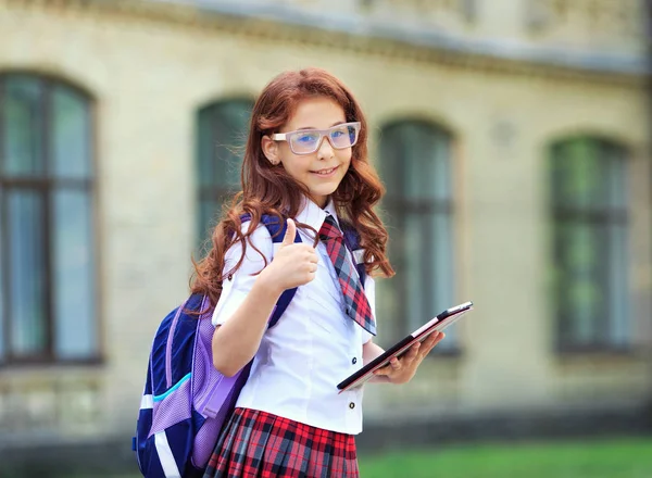 Skolflicka Med Digital Tablett Händer Står Framför Skolbyggnaden Tummen Upp — Stockfoto