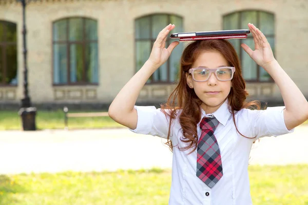 Flicka Skolflicka Håller Huvudet Bok Och Digital Tablett Baksidan Skolbyggnad — Stockfoto