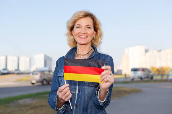 Ώριμη Γυναίκα Σημαία Γερμανίας Στέκεται Κατά Πόλη Και Μπλε Ουρανό — Φωτογραφία Αρχείου