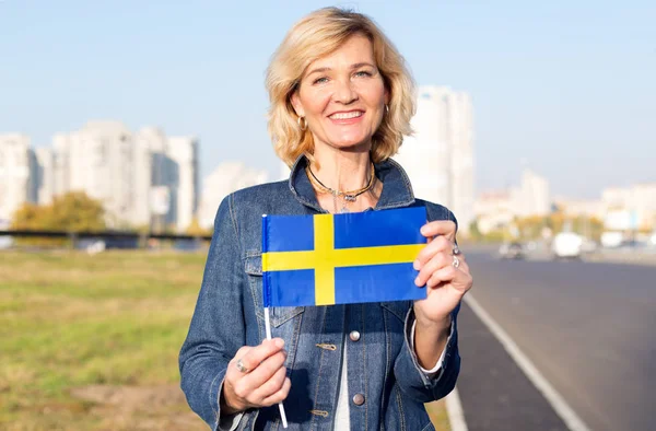 Starsza Kobieta Flaga Szwecji Tle Miasta Błękitne Niebo — Zdjęcie stockowe