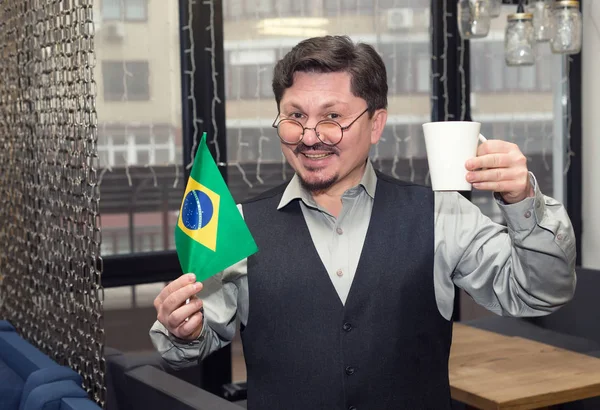 ブラジルの国旗と彼の手でコーヒー カップを持つ中年の男性 南アメリカの幸せな男 — ストック写真