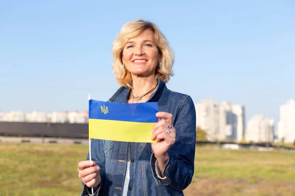 Зрелая Женщина Флагом Украины Против Голубого Неба Города — стоковое фото