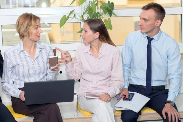 办公室的员工在喝咖啡休息的时候讨论这个消息 两个女人和一个男人谈论工作话题 — 图库照片