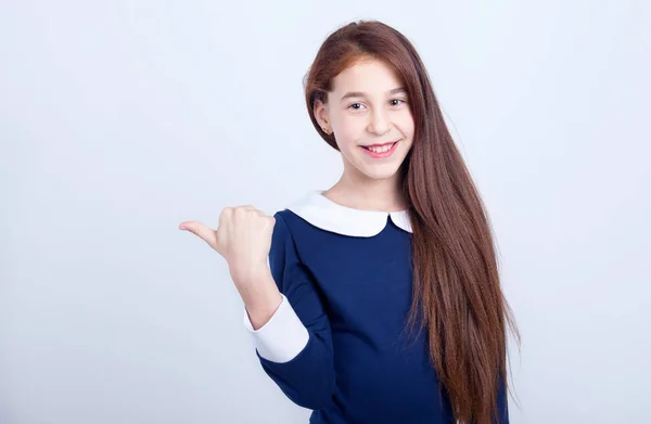 Portrait Smiling Girl Pointing Her Finger Side Light Background Schoolgirl — Stock Photo, Image