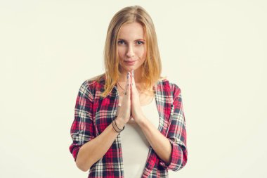 Genç kadın gülümsüyor ve dua onun önünde ellerini kıvrımlar. Meditasyon.