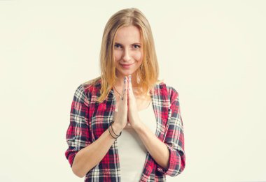 Yüzünde bir gülümseme ile mutlu genç kadın dua onun önünde ellerini katlanmış. Meditasyon.